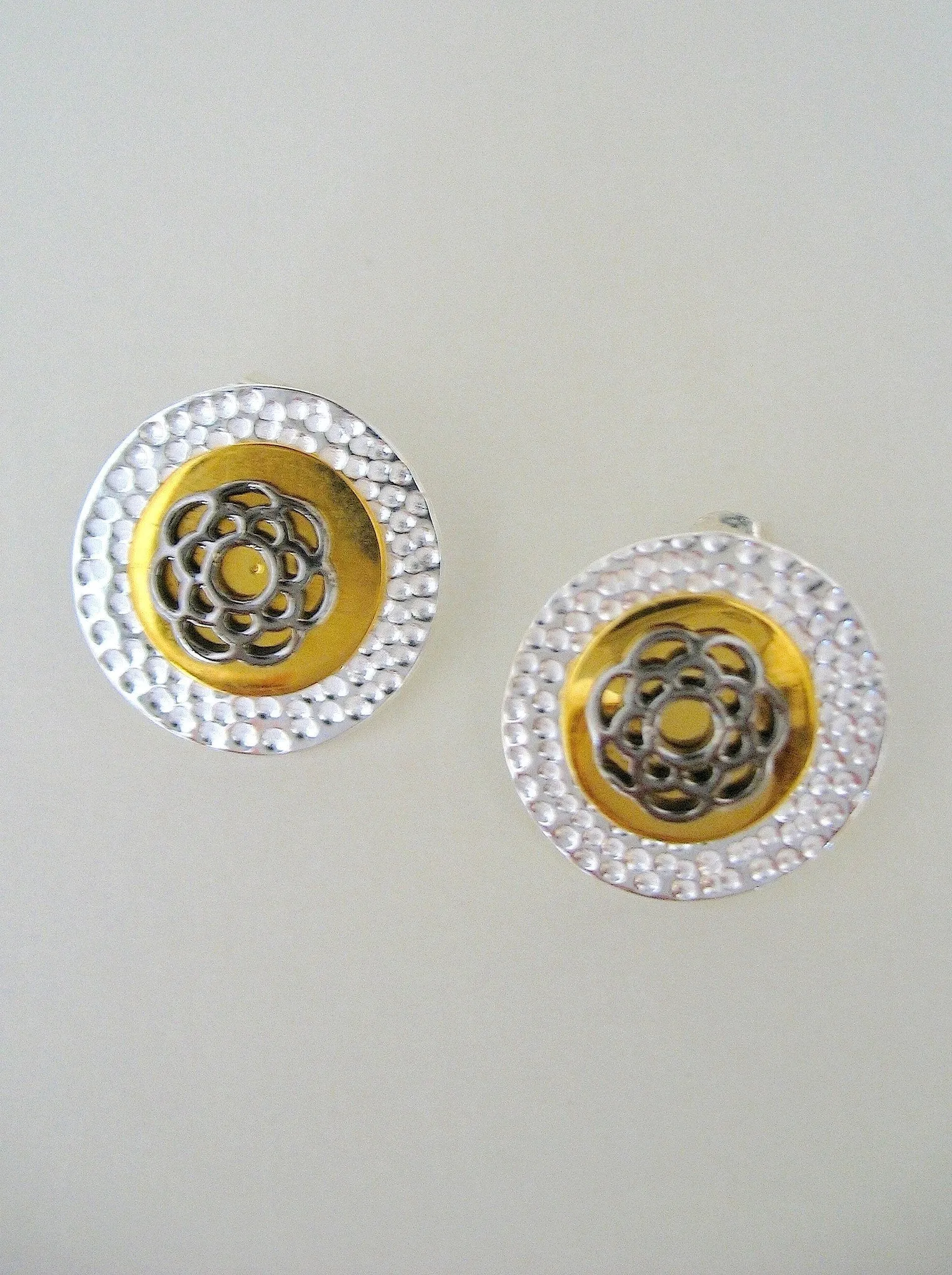 Exquisite, tri-metal,round ear studs with black rhodium plated detailing in center